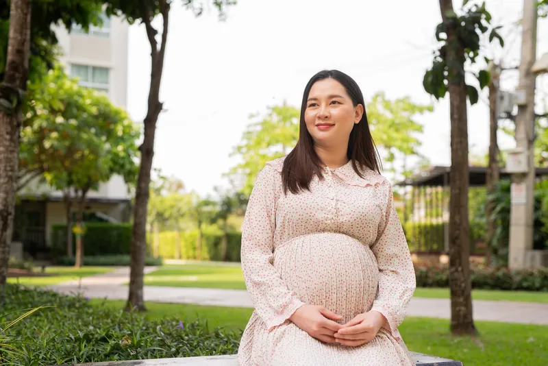 Pregnant woman relaxing outdoors in a garden setting