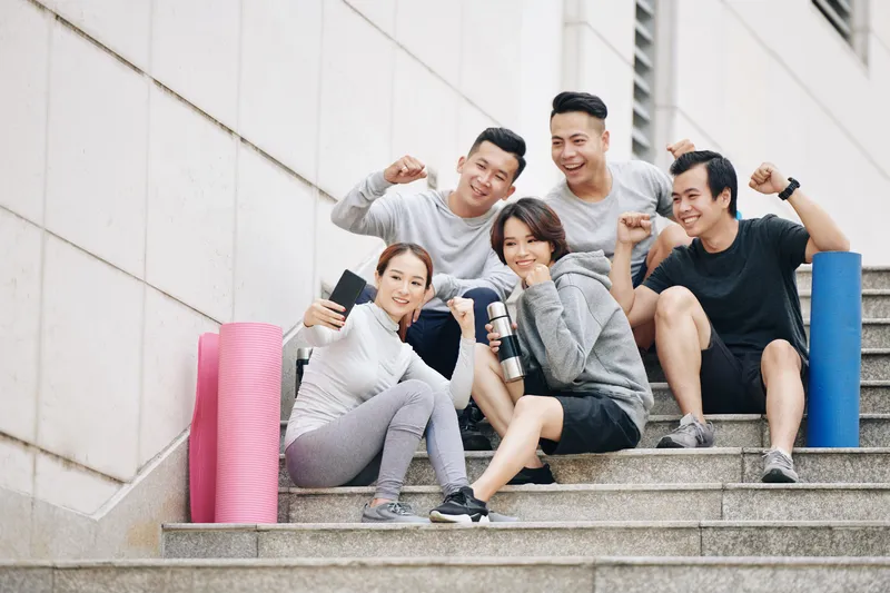 Group of friends taking a selfie after exercising outdoors, promoting healthy lifestyle habits and overall well-being in Singapore.