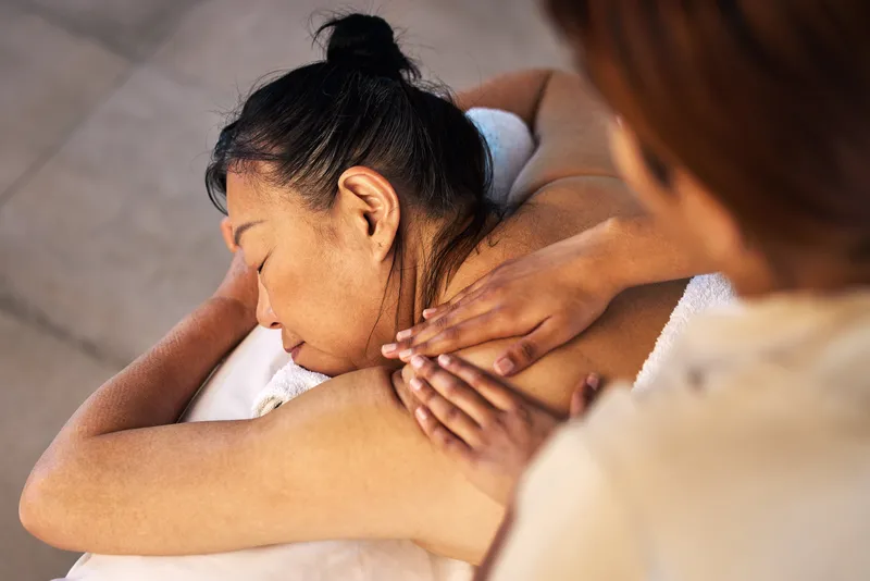 a tuina massage getting done by a TCM practitioner to an old woman in Singapore